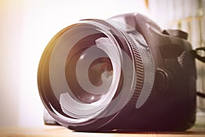 Professional camera on table, closeup. Photographer`s equipment