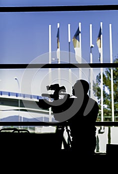 Professional cameraman covering an event. Camera operator silhouette