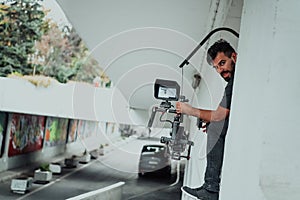 A professional cameraman with equipment and a stabilizer recoding two woman for a commercial advertisement as they run