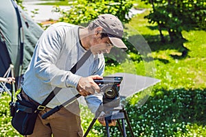 A professional cameraman prepares a camera and a tripod before shooting