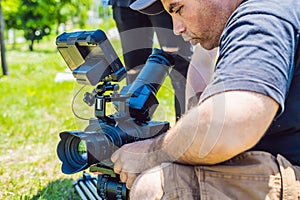 A professional cameraman prepares a camera and a tripod before shooting