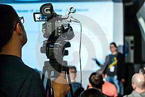 Professional cameraman with video camera on business conference