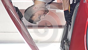 A professional car mechanic examines a car at a car service, performing a series of tests