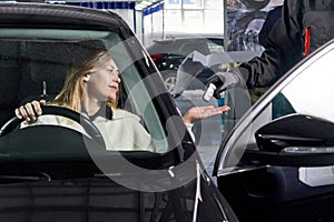 Mechanic giving car keys to female customer after servicing