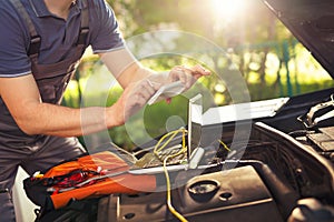 Professional car mechanic working in auto repair service, photog