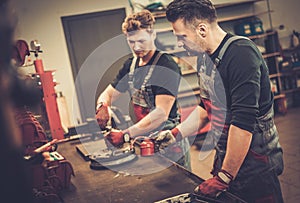 Professional car mechanics working at work table in auto repair Service.