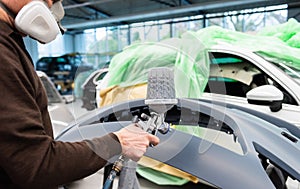 Professional car varnisher at work in a service station - Serie car repair workshop