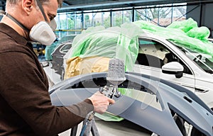 Professional car varnisher at work in a service station - Serie car repair workshop