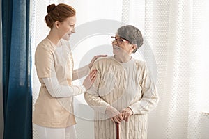 Professional caregiver assisting elderly woman