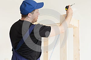 A professional carpenter makes a product from wooden boards and slats. Carpentry and manufacturing