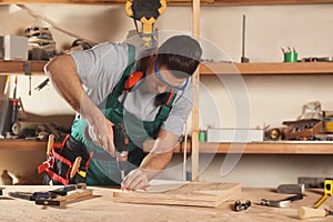 Professional carpenter twisting screw with drill