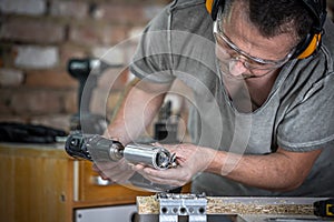 Professional carpenter working with a hinge drill, working with wood