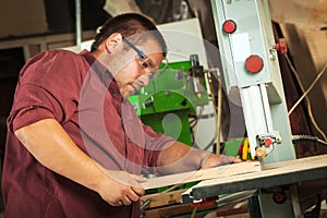 Professional carpenter working with sawing machine.