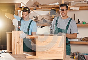 Professional carpenters assembling cabinet in workshop photo