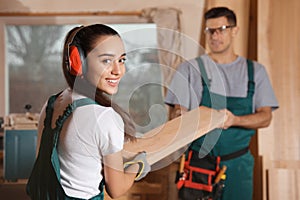 Professional carpenters with plank in workshop photo