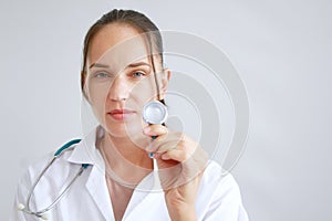 Professional Caucasian doctor woman in Gown uniform and hand holding stethoscope is smiling portrait on white wall background
