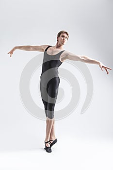 Professional Caucasian Male Ballet Dancer Flexible Athletic Man Posing in Black Tights in Ballanced Dance Pose