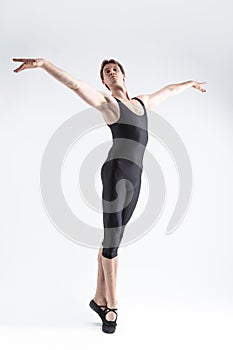 Professional Caucasian Male Ballet Dancer Flexible Athletic Man Posing in Black Tights in Ballanced Dance Pose With Hands Aligned