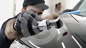 Professional ceramics handler apply different layers to the car using an applicator sponge, fiber immediately checking the effec