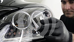 Professional ceramics handler apply different layers to the car using an applicator sponge, fiber immediately checking the effec