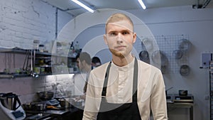 Professional chef in apron looks at camera