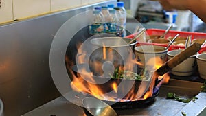 Professional chef in a commercial kitchen cooking flambe