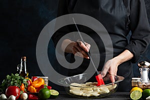 Professional chef cooking baked potato with seafood. Backstage of preparing delicious dinner on dark blur background. Frozen