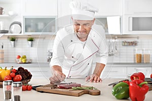 Professional chef cooking meat on table