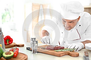 Professional chef cooking meat on table