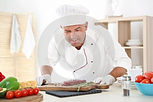 Professional chef cooking meat on table