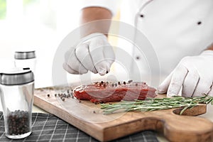 Professional chef cooking meat on table