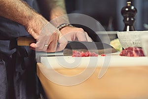 Professional chef cutting meat in the kitchen
