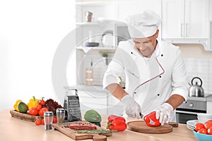 Professional chef cutting pepper on table