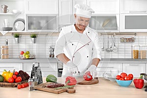Professional chef cutting pepper on table