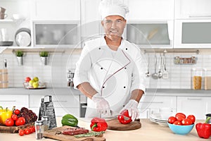 Professional chef cutting pepper on table