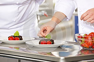 Professional chef decorate dessert cake with strawberry