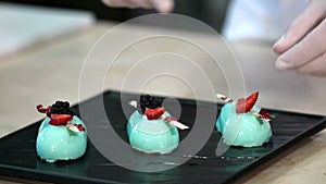 Professional chef garnishing glazed desserts