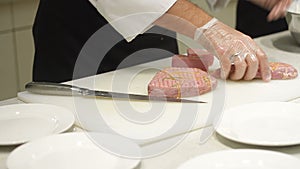 Professional chef hands cutting cooking red fish fillets tuna
