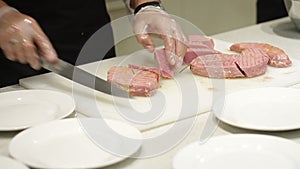 Professional chef hands cutting cooking red fish fillets tuna