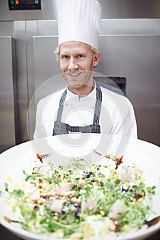 Professional, chef and man portrait or salad, restaurant and cooking staff for gourmet meal prep. Smile, catering and