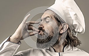 Professional chef man showing sign for delicious. Chef, cook making tasty delicious gesture by kissing fingers. Cook hat