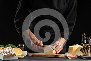 A professional chef prepares a fresh and healthy Italian salad slicing mazzarella cheese, Organic and wholesome food. Healthy