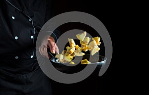 Professional chef prepares zucchini in a pan. Cooking vegetables healthy vegetarian food and meal on dark background. Free