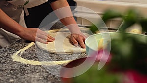 professional chef preparing pizza dough, shaping the dough