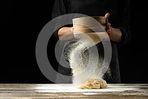 A professional chef in a professional kitchen prepares dough from flour to cook Italian pasta, pizza, the concept of nature, Italy