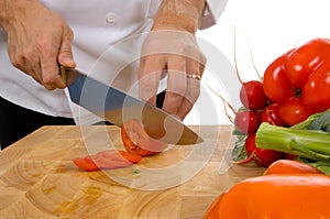Professional chef slicing tomato