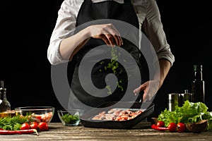 Professional chef sprinkles shrimps for salad, seafood and healthy food concept. Horizontal photo, menu, recipe book
