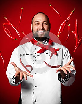 Professional chef in uniftrow red hot chili pepper on kitchen of the restaurant