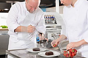 Professional chefs decorate dessert cake with lemon leaf