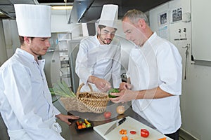 Professional chefs prepare steak dish at restaurant